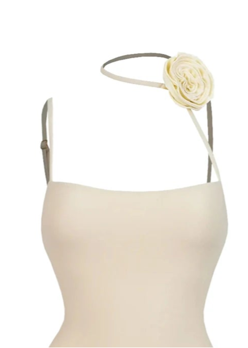 Beige swimsuit with floral details and a white background
