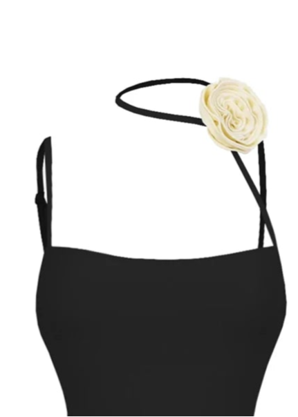 Black swimsuit with ruched design and fringes on a white background