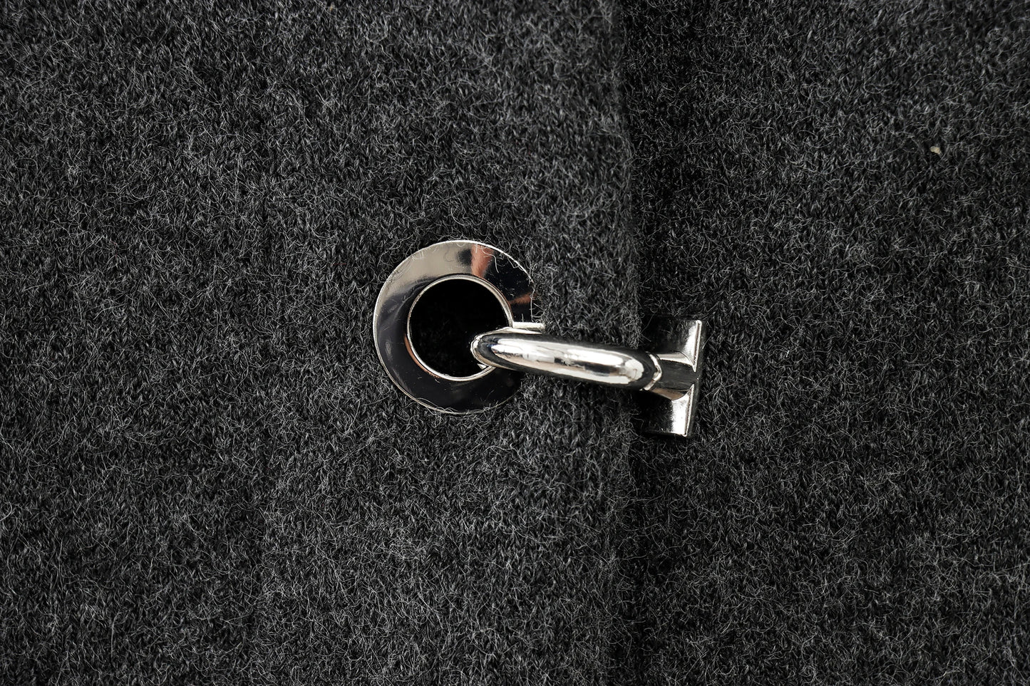Close-up of a keyhole on a textured black cape
