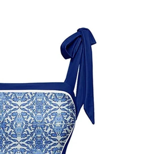 Blue and white patterned swimsuit with bow straps on a white background