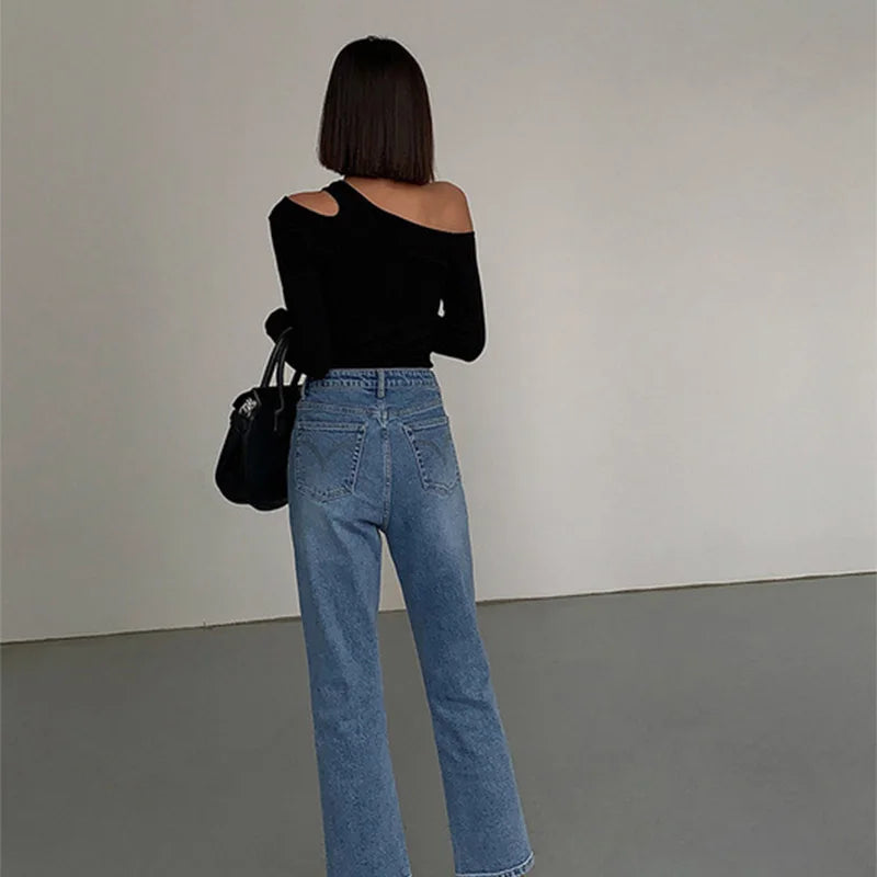 Back view of the black asymmetric off-shoulder top, showcasing its elegant design and stylish cut.