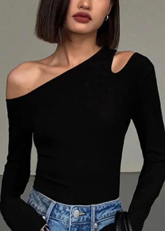 Close-up of the black asymmetric off-shoulder top, focusing on the fabric texture and off-shoulder detail.