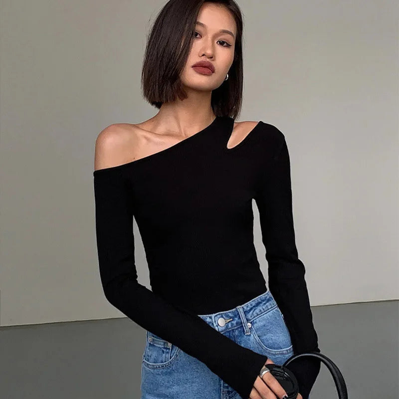 Side view of the black asymmetric off-shoulder top, illustrating its unique silhouette and stylish design.