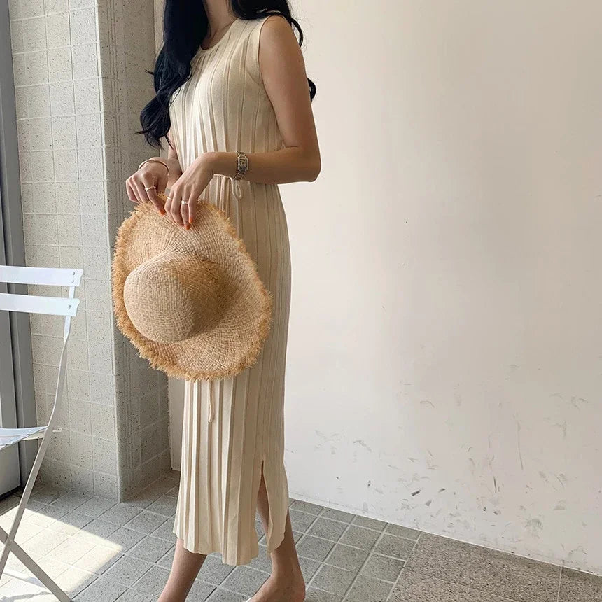 Modern beige knitted dress featuring a mid-calf length and a relaxed fit for everyday elegance.