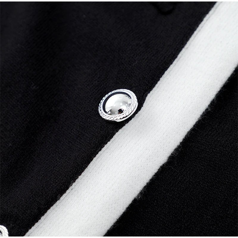 Close-up of the black knit ribbed mini dress featuring elegant button details, showcasing its stylish design and texture.