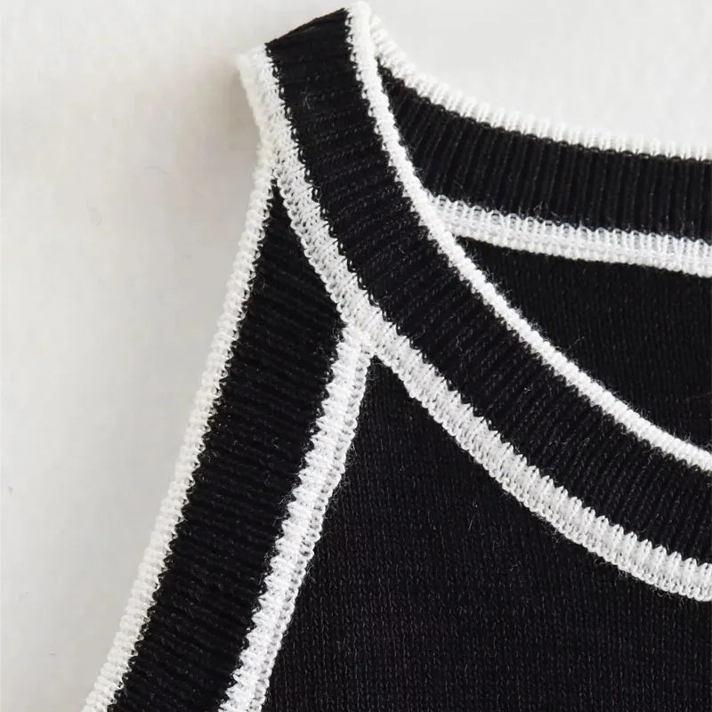 Close-up of the collar on the black knitted crop tank, featuring the contrasting black and white striped details.