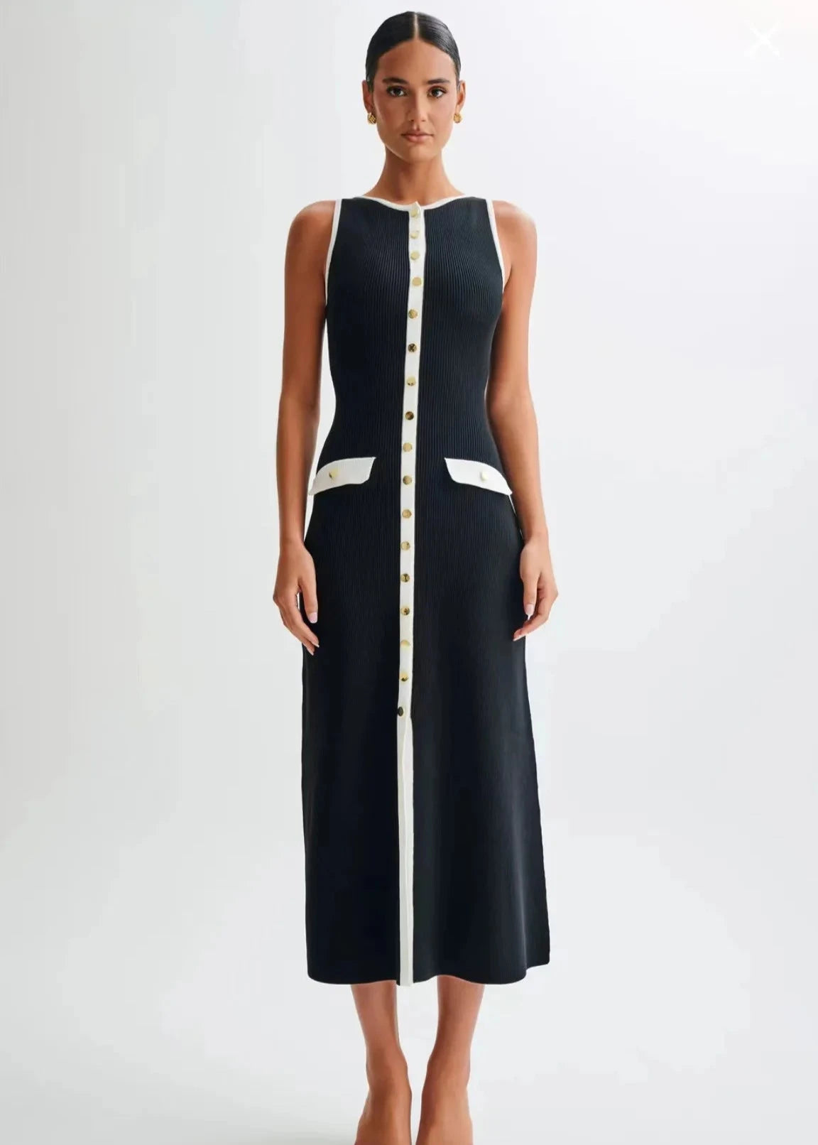 Model standing straight in the black knitted mid-calf dress, showcasing its elegant silhouette.