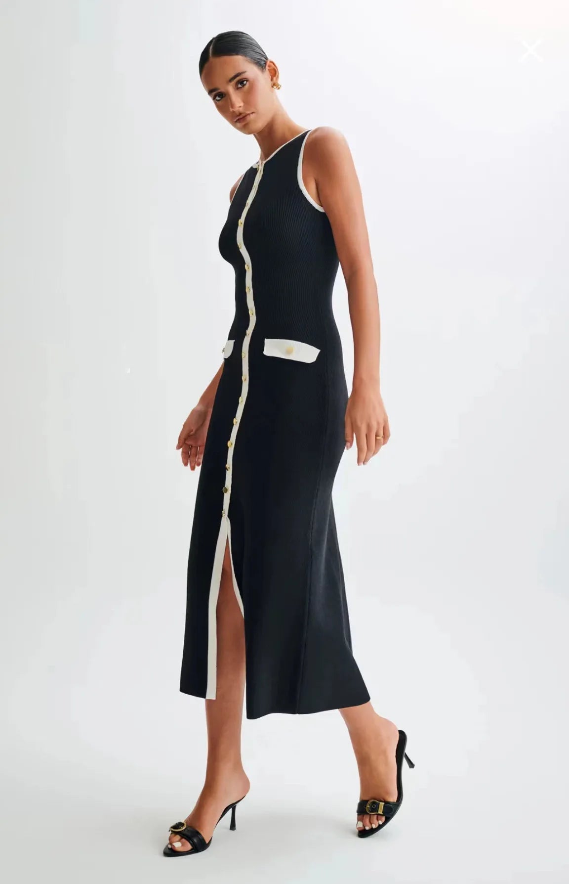Model walking wearing the black knitted mid-calf dress, demonstrating its versatility and style.