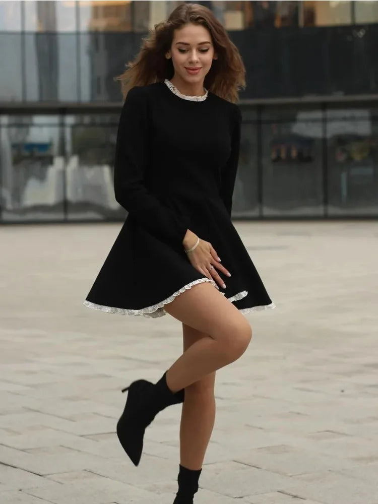 Right side view of the model wearing the black lace mini dress, emphasizing the lace pattern and form.