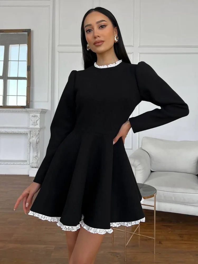 Side view of the model wearing the black lace mini dress, highlighting the silhouette and lace design