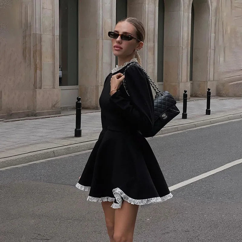 Side view of the model wearing the black lace mini dress, with a focus on the lace texture and side profile.