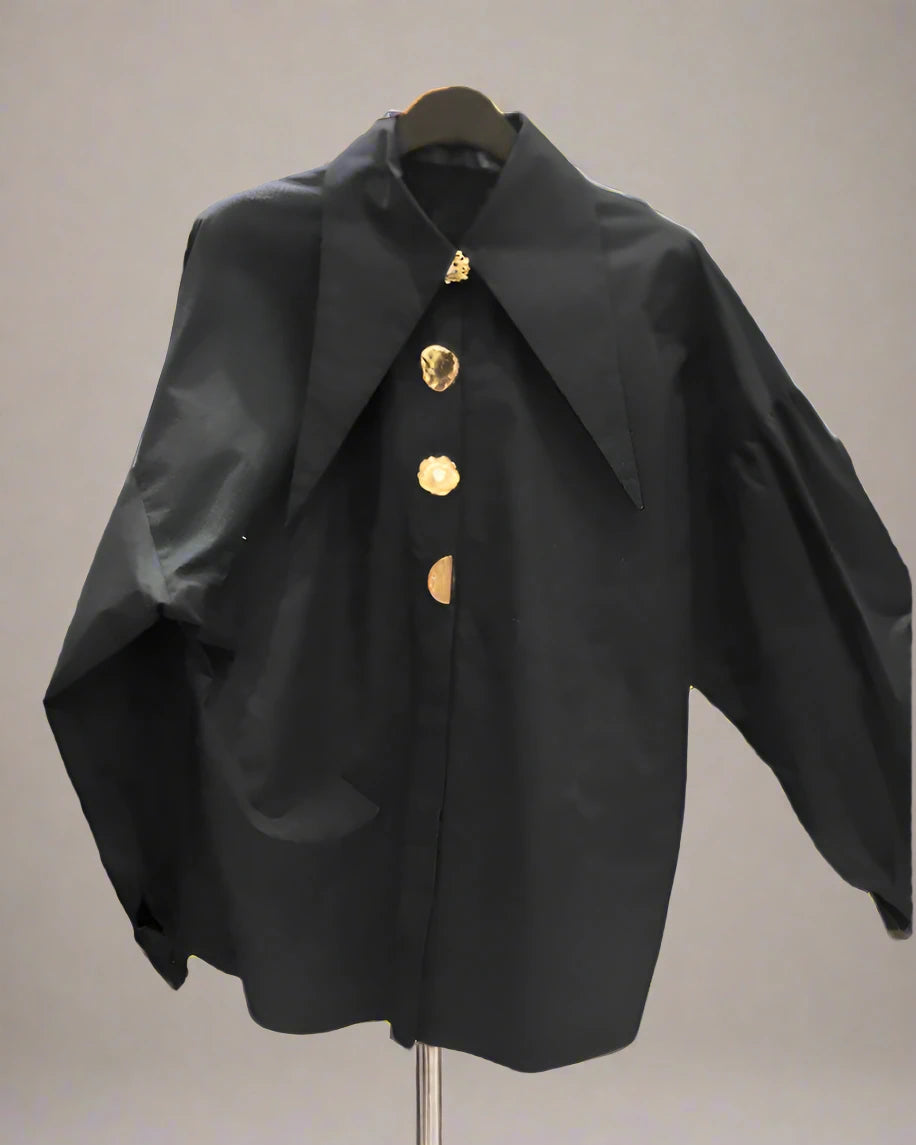 Classic black blouse with a long collar and large gold pearl buttons for a sophisticated and timeless style.
