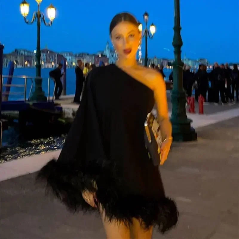 Chic black one-shoulder feather spliced mini dress, perfect for evening glamour.