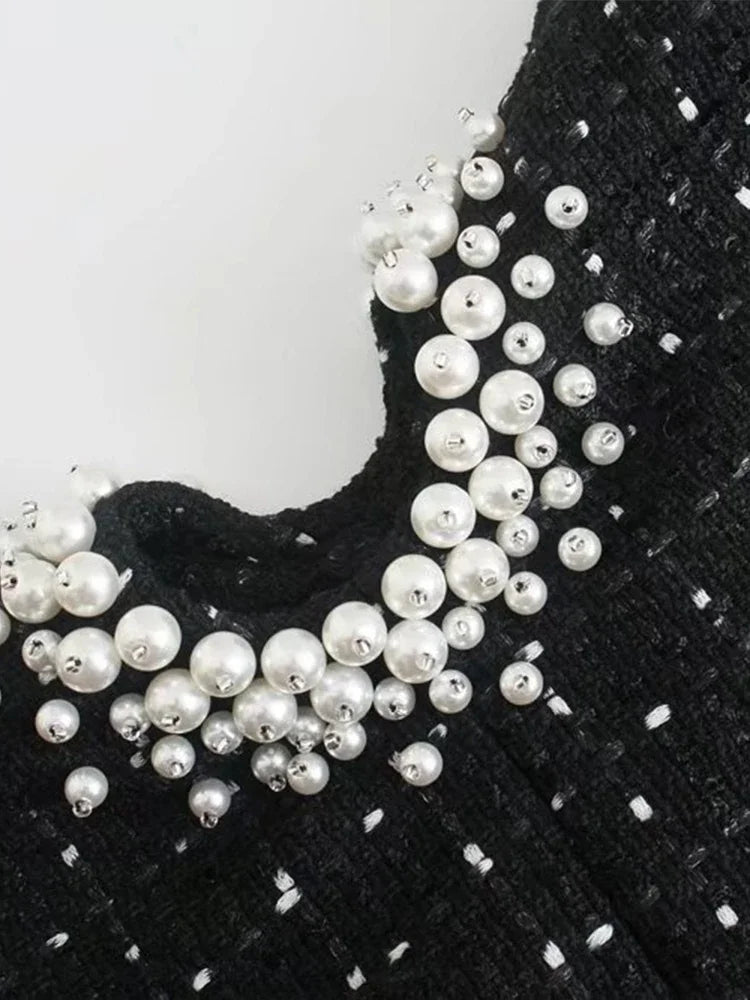 Black pearl-embellished tweed mini dress, timeless and elegant.