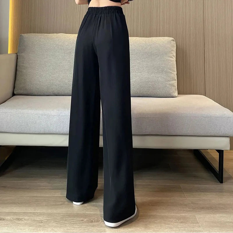Classic black wide-leg pants with a high waist, combining elegance with comfort.