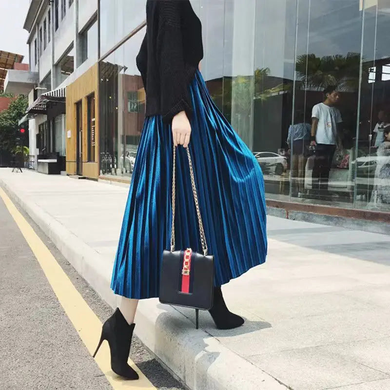 Elegant blue pleated velvet midi skirt with an A-line silhouette and elastic high waist, perfect for autumn and winter fashion.