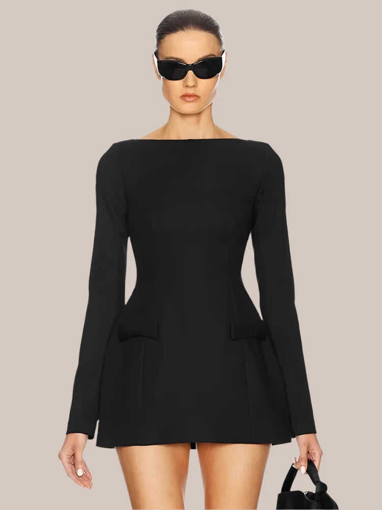 Model wearing the black Bows Splice Mini Dress, highlighting the front design and bow detail.