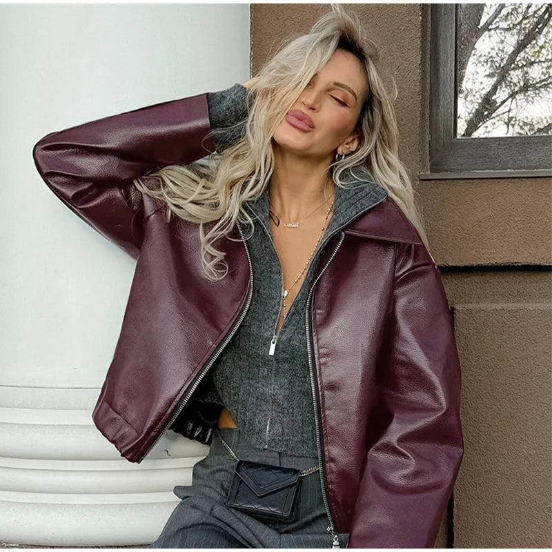 Blonde model in a burgundy faux leather jacket, demonstrating a chic and versatile style.