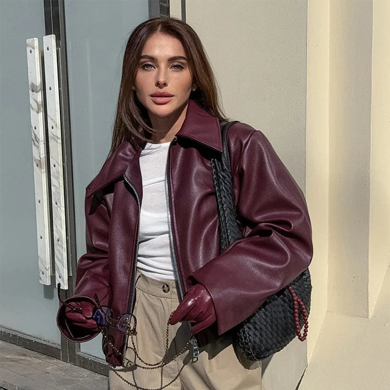 Brunette model wearing a burgundy faux leather jacket, showcasing an elegant and timeless appearance.