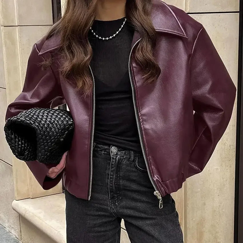 the model wearing a burgundy faux leather jacket, highlighting the jacket’s silhouette.