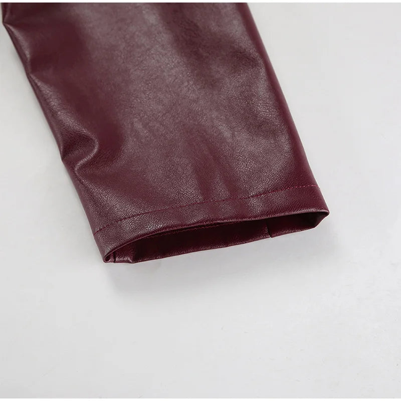 Close-up of the sleeve detail on the burgundy faux leather jacket, emphasizing the craftsmanship and smooth finish
