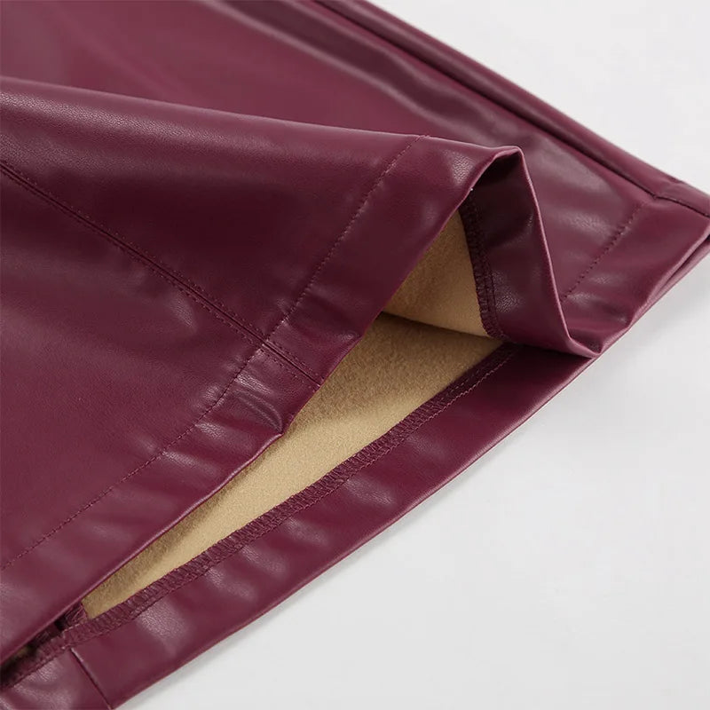 Close-up of the hem of the Burgundy Leather Mini Skirt, showing its neat finishing details.