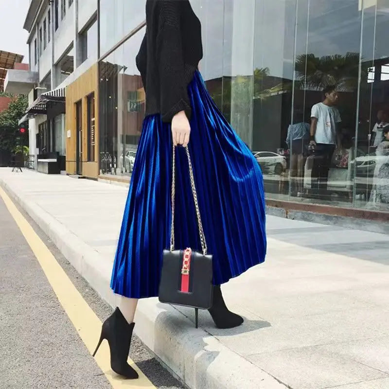 Sophisticated deep blue pleated velvet midi skirt featuring a mid-calf length and premium fabric for chic winter style.