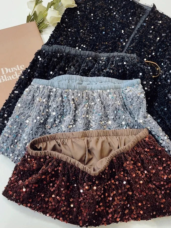 Detailed view of velvet sequin midi skirts in multiple colors, showcasing the quality stitching and fabric sheen.