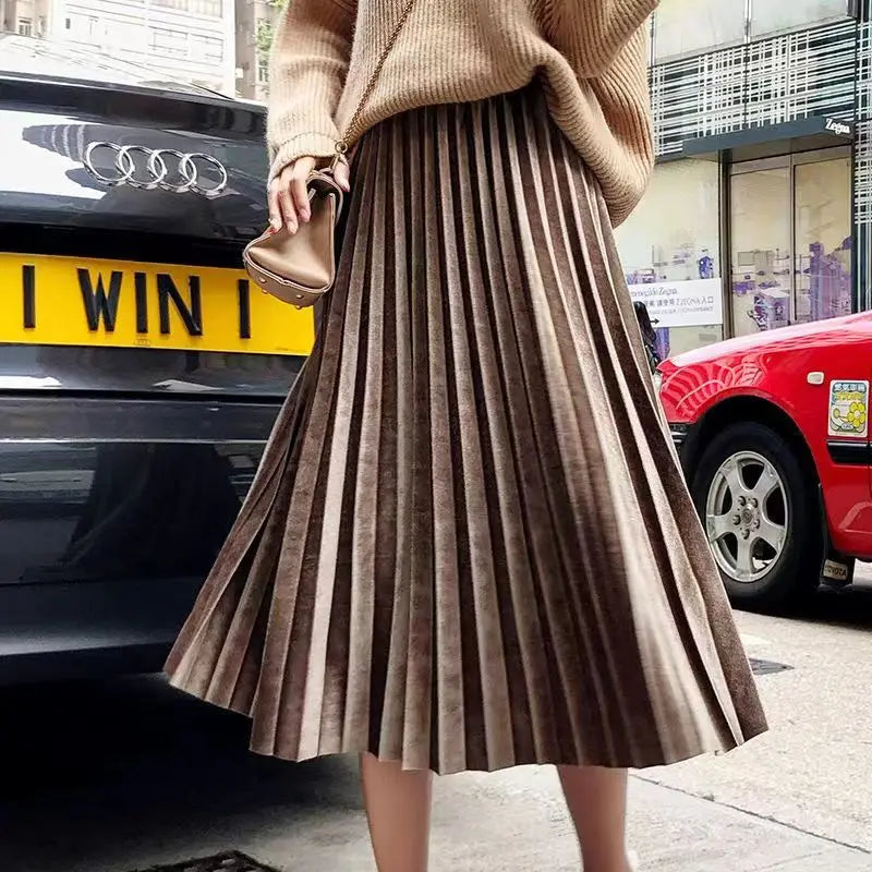 Warm khaki pleated velvet midi skirt with an A-line silhouette, ideal for casual autumn and winter outfits.