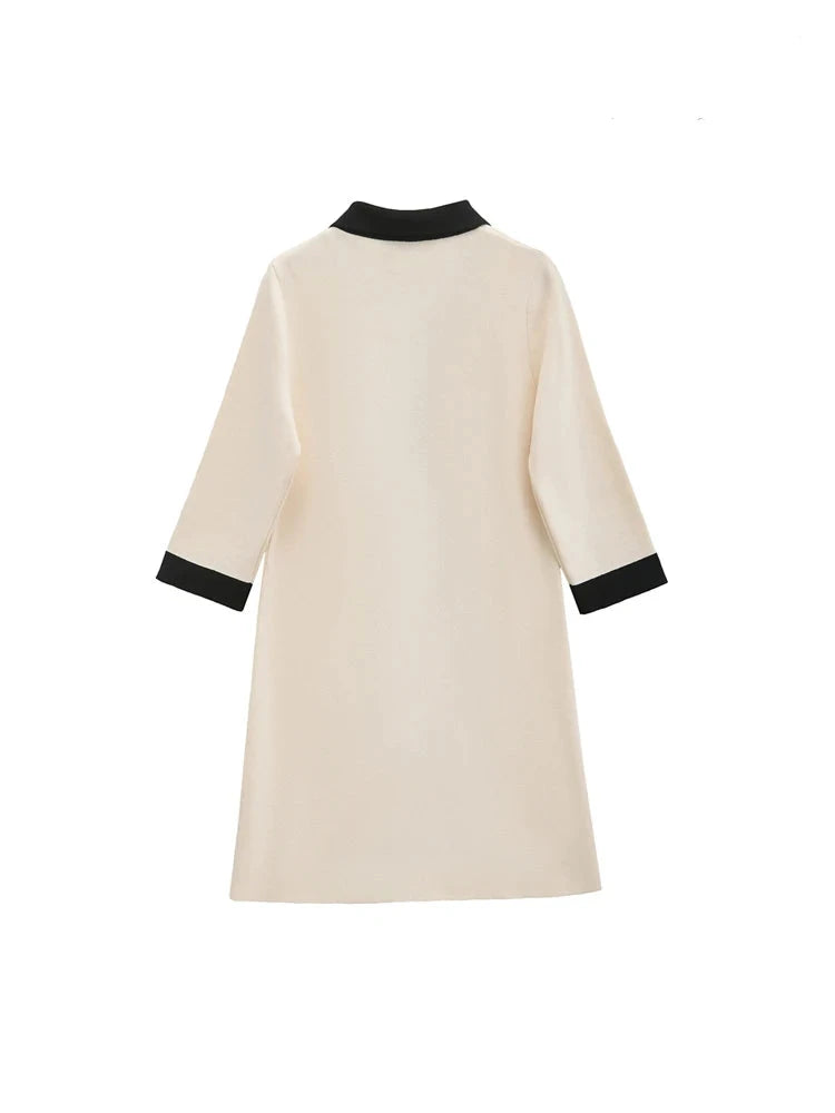 Classic elegance of a cream beige knitted mini dress with striking black contrast and luxurious gold button accents