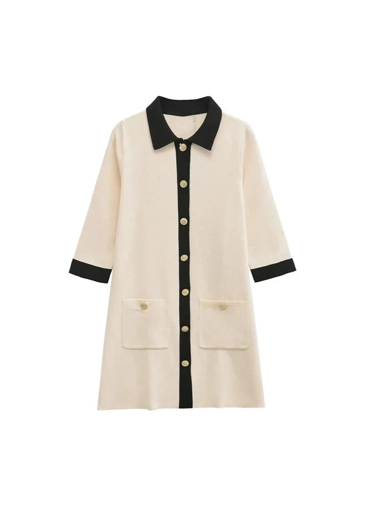 Elegant knitted mini dress in cream beige with black contrast trim and gold buttons, showcasing a chic and sophisticated style
