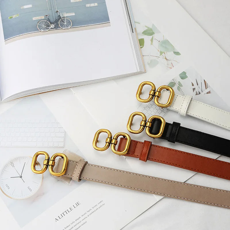 Collection of leather belts in black, white, khaki, and brown, each with a stylish metal buckle.