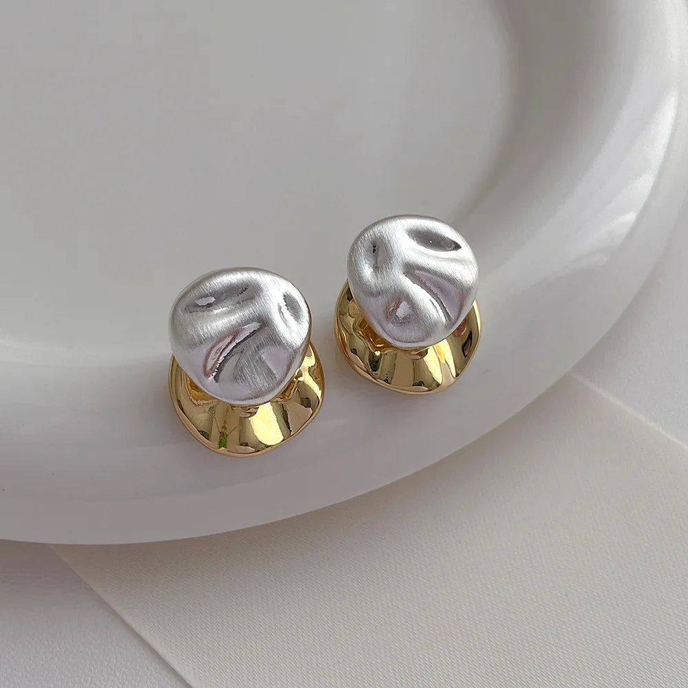 Round mixed silver and gold earrings, perfect for adding elegance to any outfit.