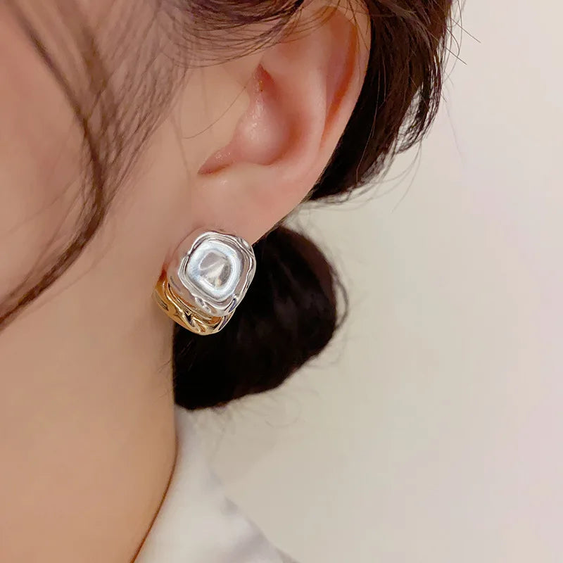 Bold square-shaped earrings in mixed silver and gold for a contemporary look.