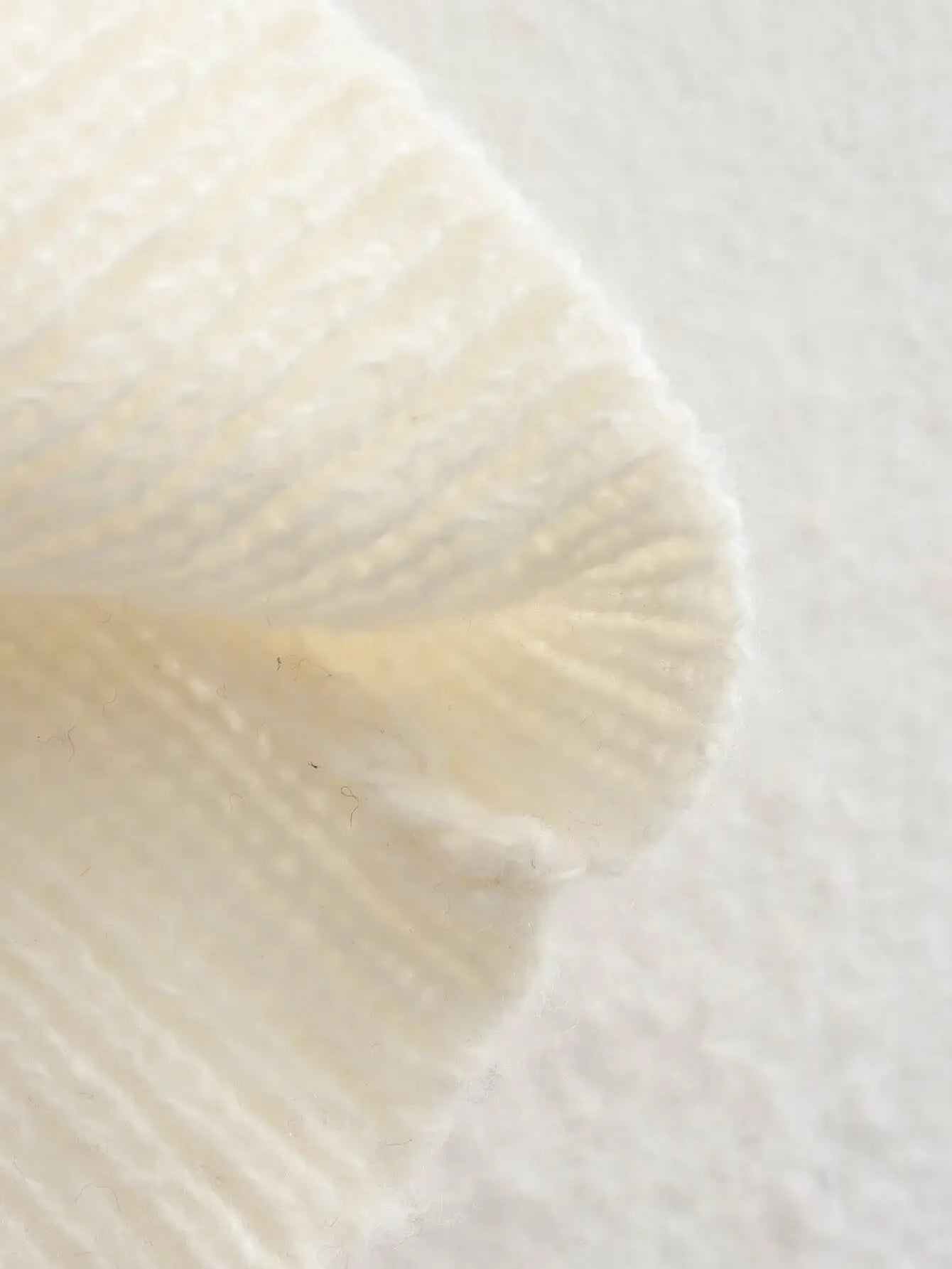 Neutral beige knitted sweater with an off-shoulder design, perfect for casual elegance.