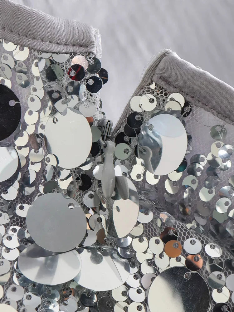 Closeup of the silver sequined mini skirt's luxurious details and sparkling texture.
