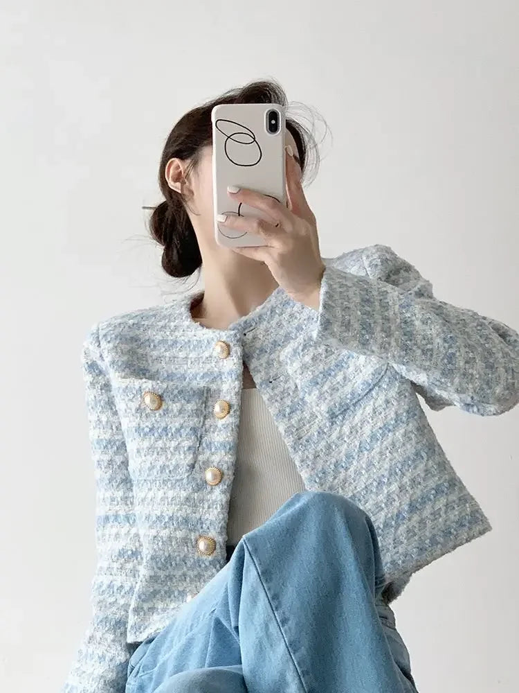 Close-up of the elegant tweed jacket, showcasing the intricate fabric blend in white, blue, and grey for an elevated fashion look.
