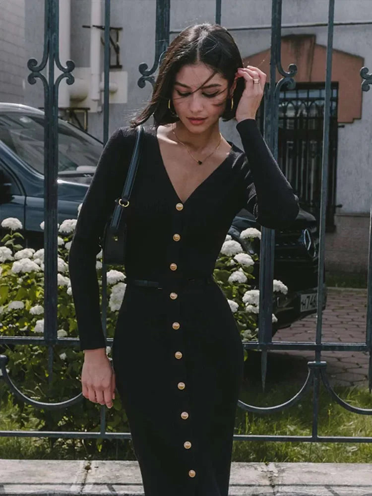 Black V-neck knitted long dress worn by model, presenting a sleek and sophisticated look.