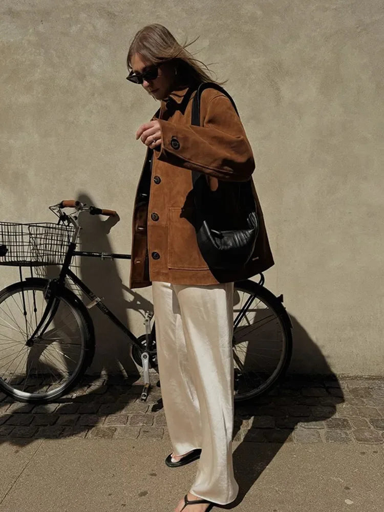 Warm brown suede jacket styled for winter layering, combining elegance and practicality.