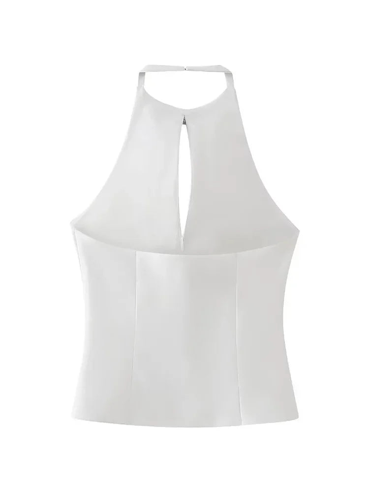 Close-up of backless design with diamond bow accent on white halter neck top for a classy look.