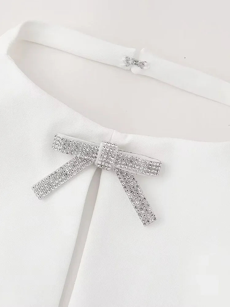 White halter neck top featuring a diamond bow for elegant night out attire.