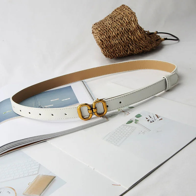 White leather belt with a sleek metal buckle, perfect for minimalist and elegant outfits.