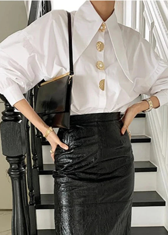 White blouse with long collar and large gold pearl buttons for a chic, elegant look.