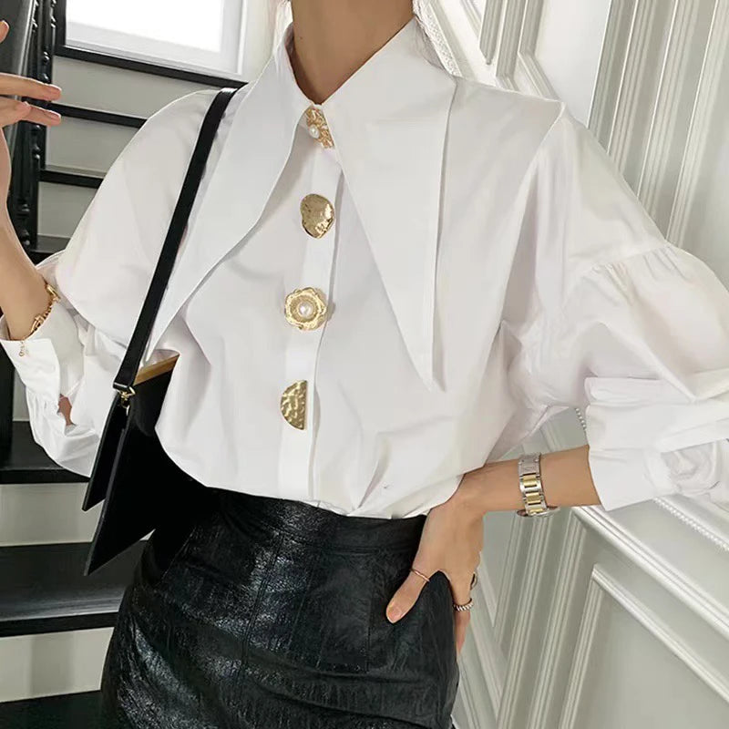 Stylish white blouse featuring an exaggerated long collar and gold pearl buttons.