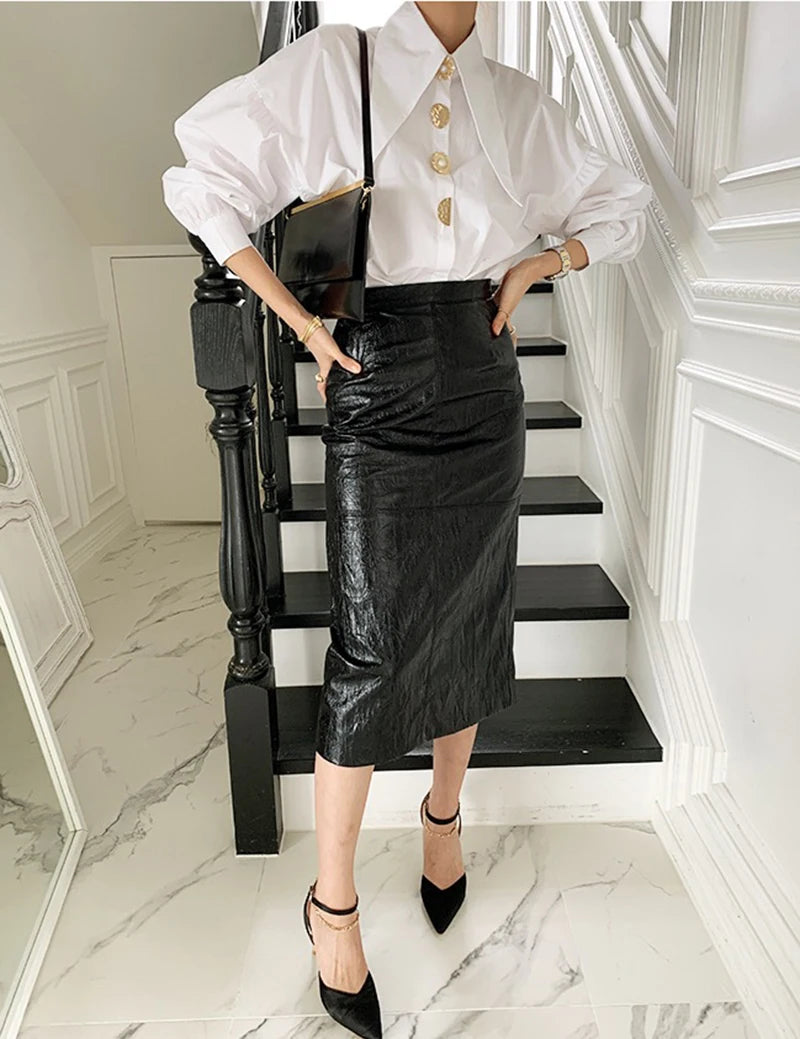 Chic white blouse with a long collar and eye-catching gold pearl buttons, adding luxury to any outfit.