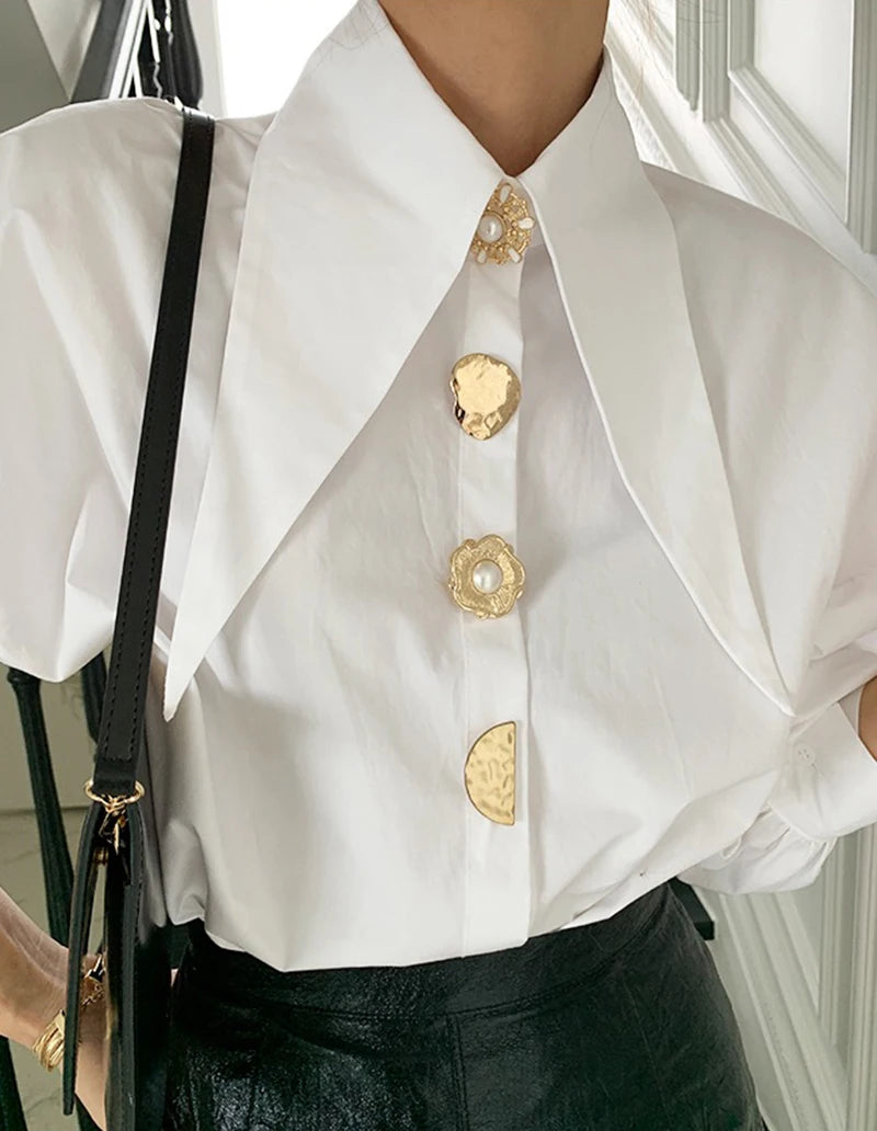 Elegant white blouse with long collar and gold pearl buttons, a perfect choice for modern fashion lovers.