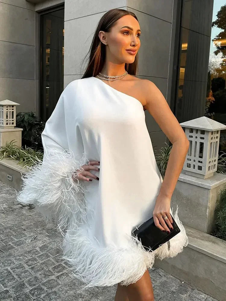 Elegant white one-shoulder feather spliced mini dress, perfect for chic evening events.