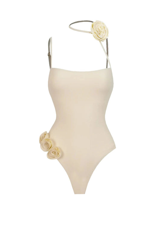 Beige one-piece swimsuit with floral details on a white background