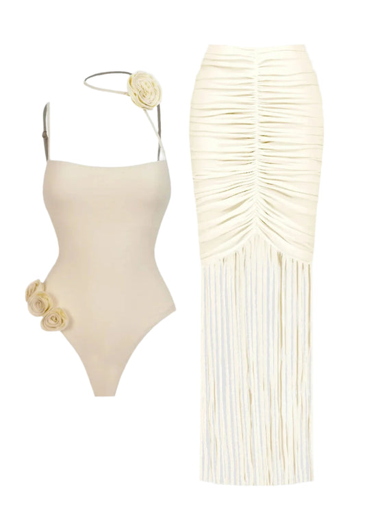 Beige swimsuit with floral details and matching fringed skirt on a light gray background
