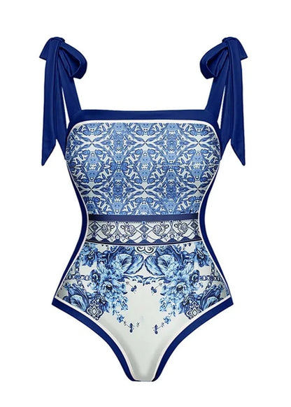 Blue and white patterned swimsuit with bow straps on a white background